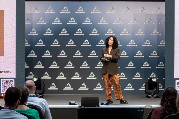 Blick aus dem Publikum auf Julia Kreft auf der Finance-Summit-B&uuml;hne